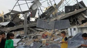 Children near destroyed solar panels in Gaza