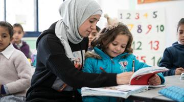 A teacher works with students in a school in Ramallah, West Bank